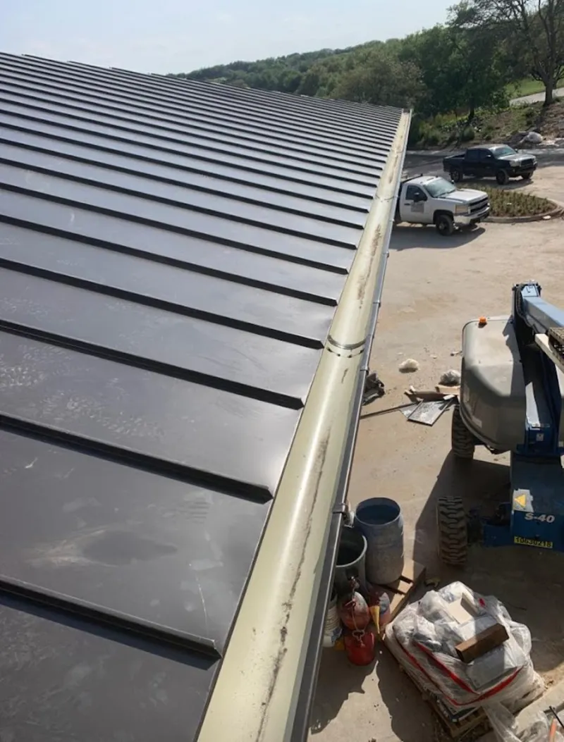Standing seam panel and gutter detail on a metal roofing jobsite in Kennedy